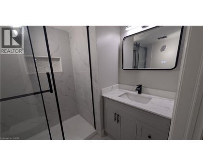A bathroom with a sink, mirror, and shower.