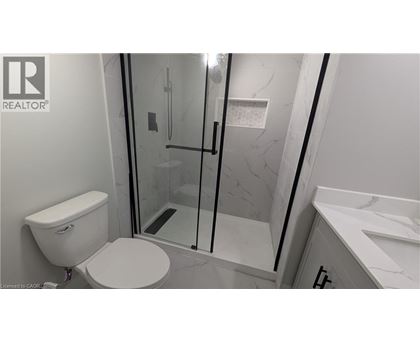 A white toilet in a bathroom with a glass shower door.