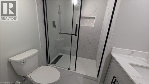 A white toilet in a bathroom with a glass shower door.