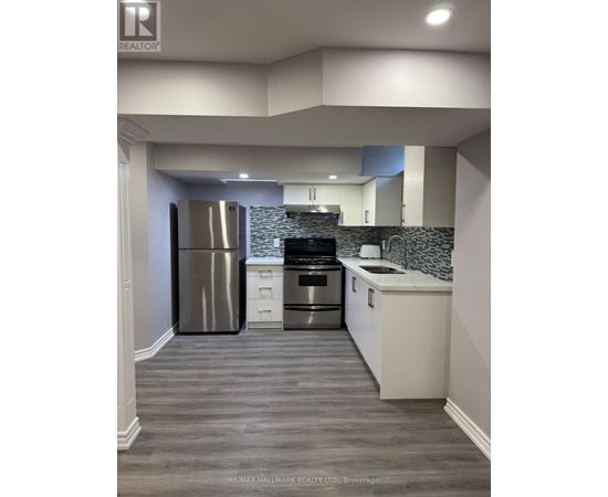 A modern kitchen with a stainless steel refrigerator and a tiled backsplash.