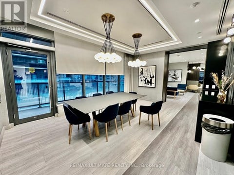 A modern dining room with a long table and chairs.