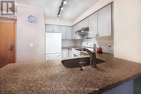 A kitchen with a sink and a refrigerator.
