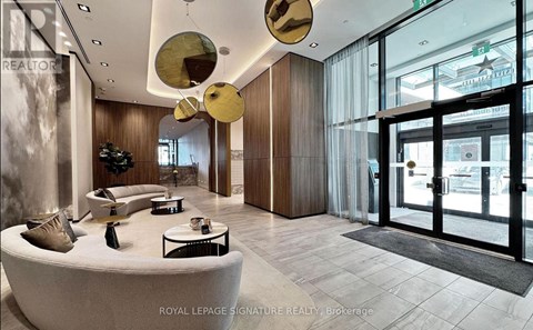 A modern interior space with a curved white couch and a glass door.