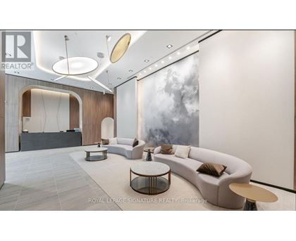 A modern living room with a large grey sofa and a coffee table.