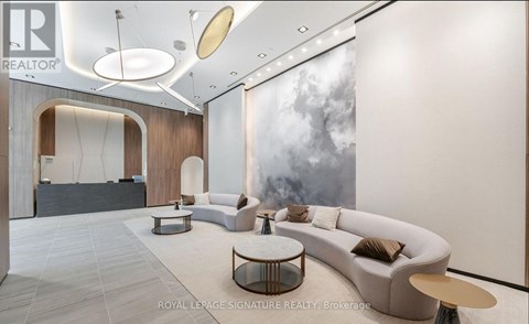 A modern living room with a large grey sofa and a coffee table.