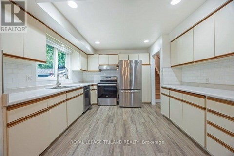 A kitchen with white cabinets and a wooden floor.