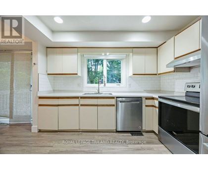 A kitchen with white cabinets and a window.