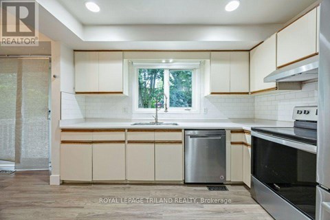 A kitchen with white cabinets and a window.