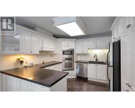 A kitchen with white cabinets and a black countertop.