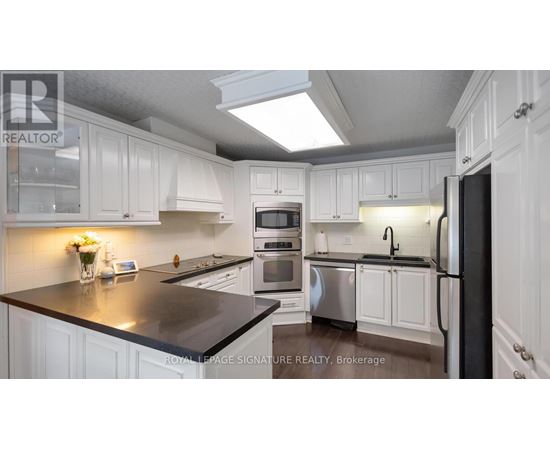 A kitchen with white cabinets and a black countertop.