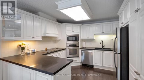 A kitchen with white cabinets and a black countertop.