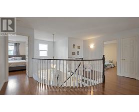 A bedroom with a white bed and a white railing.