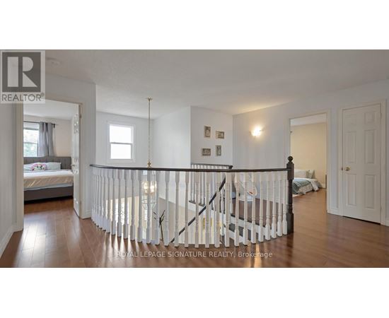 A bedroom with a white bed and a white railing.