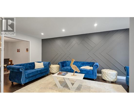 A living room with a blue couch and a wooden sculpture on the coffee table.