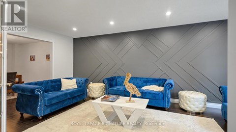 A living room with a blue couch and a wooden sculpture on the coffee table.
