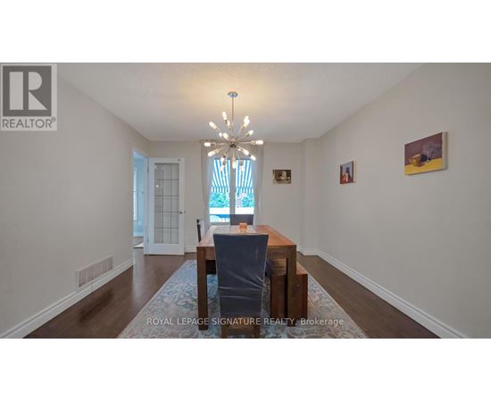 A dining room with a table and chairs.