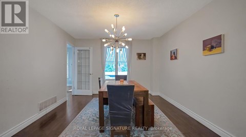 A dining room with a table and chairs.