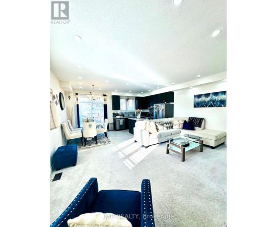 A living room with a white couch and a blue chair.