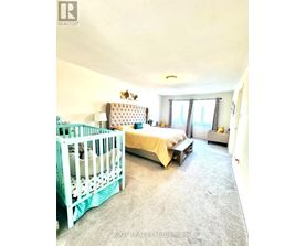 A bedroom with a white bed and a white crib.