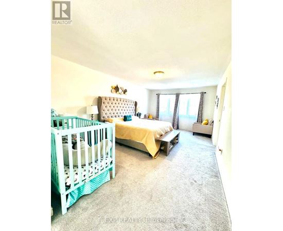 A bedroom with a white bed and a white crib.