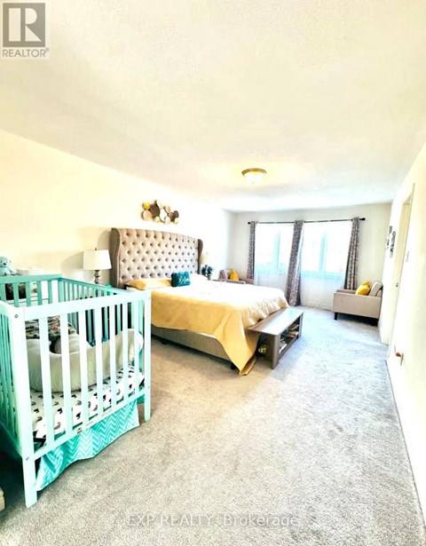 A bedroom with a white bed and a white crib.
