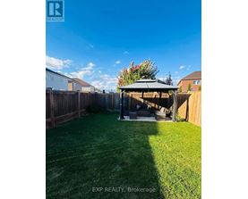 A backyard with a gazebo and a fence.