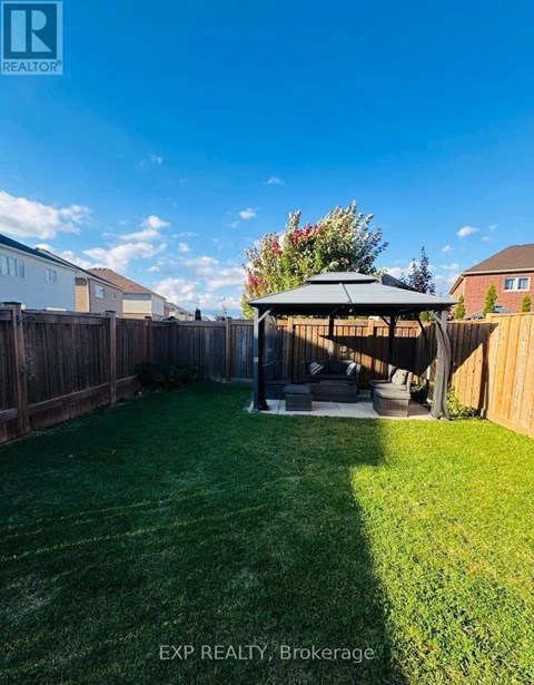 A backyard with a gazebo and a fence.
