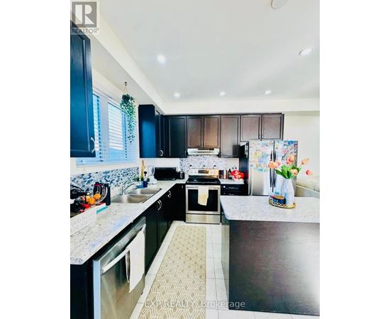 A kitchen with black cabinets and a patterned tile floor.