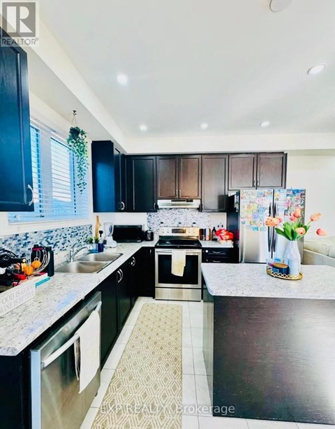A kitchen with black cabinets and a patterned tile floor.