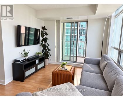 A living room with a grey couch and a wooden coffee table.