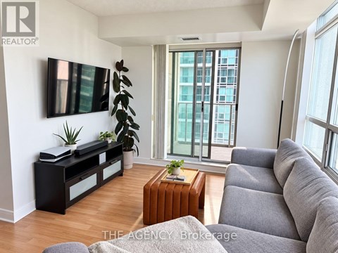 A living room with a grey couch and a wooden coffee table.