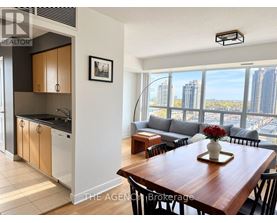 A modern kitchen with a dining table set with a vase of flowers.
