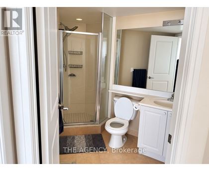 A bathroom with a toilet, sink, and shower.