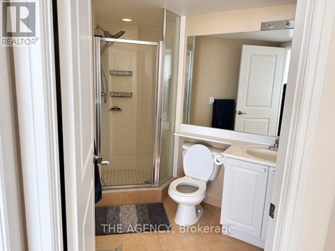 A bathroom with a toilet, sink, and shower.