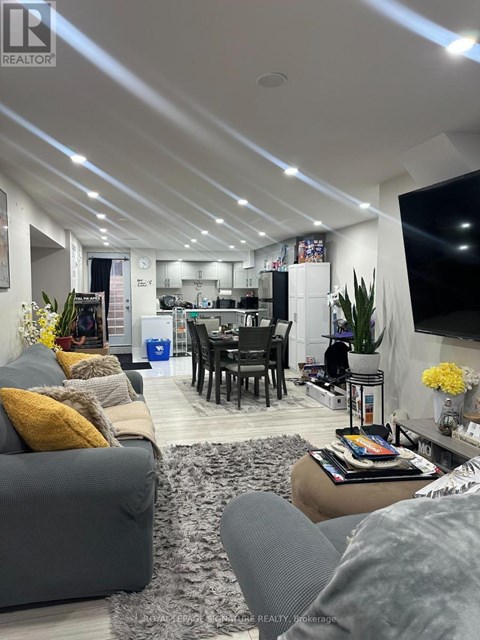 A modern living room with a grey couch and a grey rug.