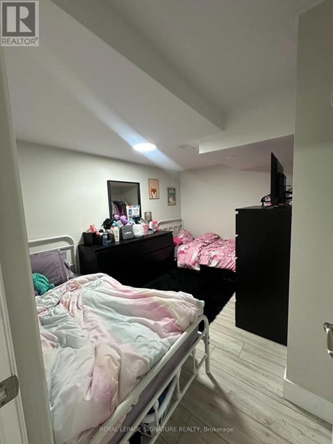 A bedroom with a bed, a dresser, and a mirror.