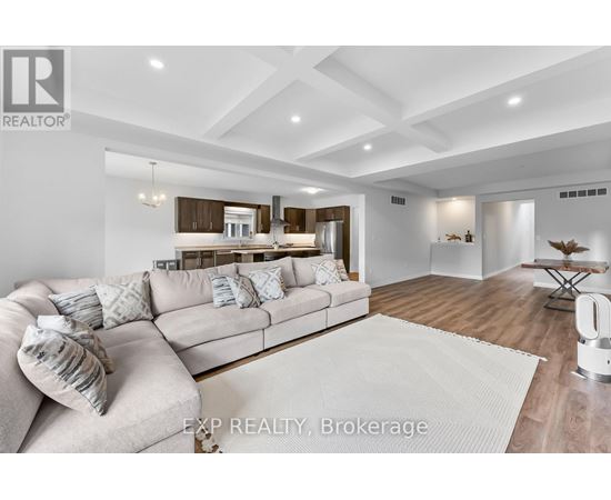 A modern living room with a large couch and a kitchen in the background.