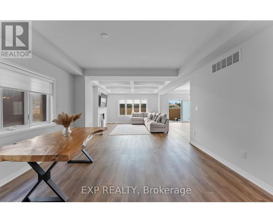 A spacious living room with a wooden table and white sofas.