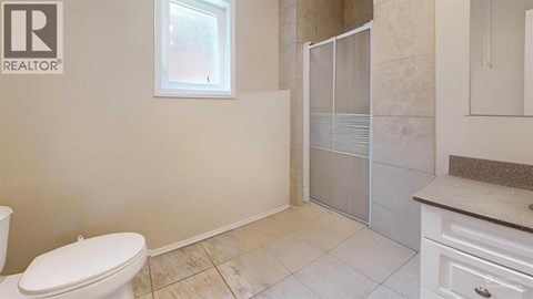 A bathroom with a toilet, sink, and shower.