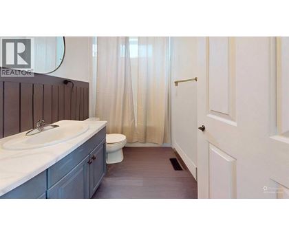 A bathroom with a sink, toilet and shower curtain.