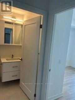 A white bathroom with a sink and mirror.