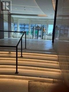 A staircase with a black railing and lighting on the steps.