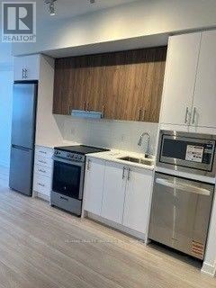 A modern kitchen with white cabinets and stainless steel appliances.