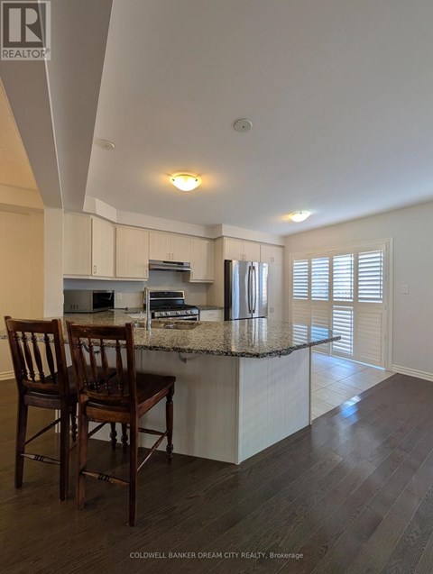 Two wooden chairs are placed on a kitchen island.