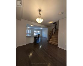 A large open space with a wooden floor and a staircase.