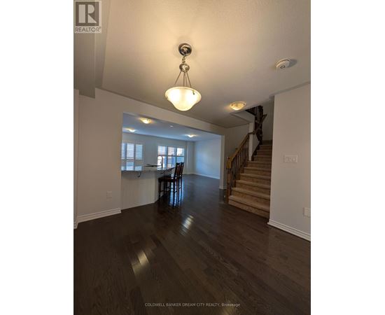 A large open space with a wooden floor and a staircase.