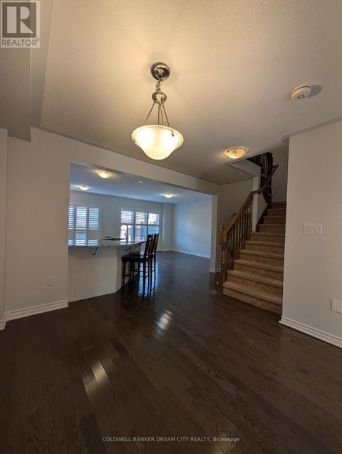 A large open space with a wooden floor and a staircase.