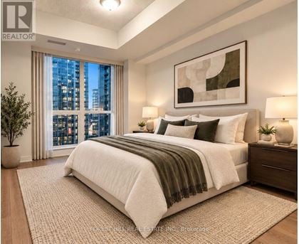 A well-lit bedroom with a large bed and a city view through the window.