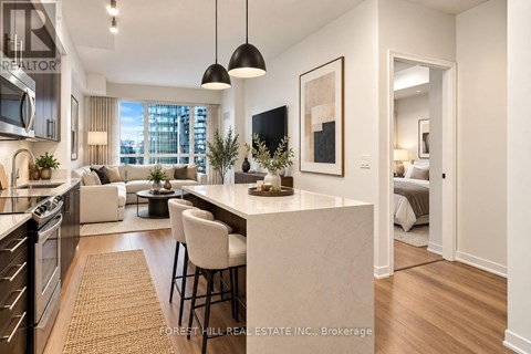 A modern kitchen with a dining area and a living room with a couch and a bed.