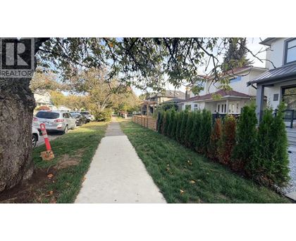 A residential street with houses on both sides and a sidewalk in the foreground.